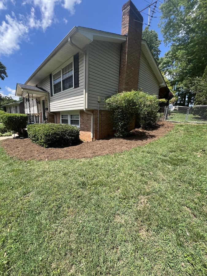 Brick home foundation bed mulch refresh